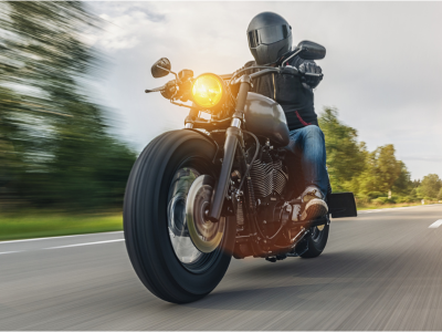 A motorcyclists cruises on a road.