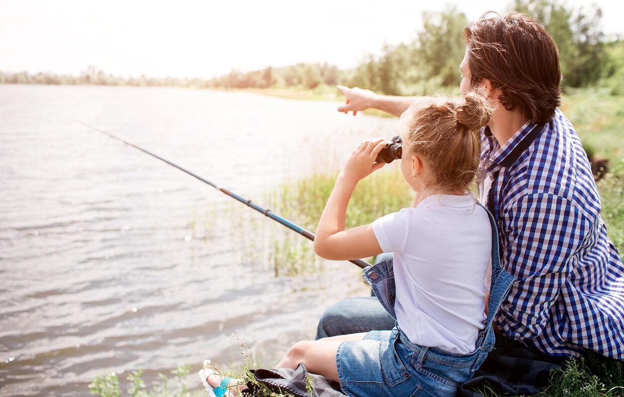 little girl and middle aged man fishing on a lake