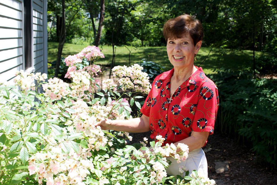 Bela stands near flowers smiling