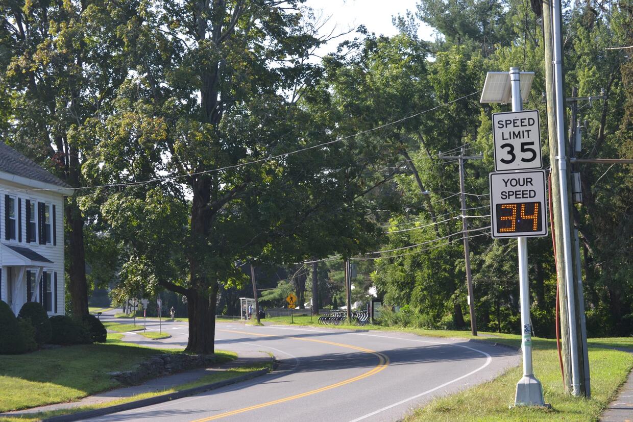 Speed Feedback sign with speed limit sign on two lane road