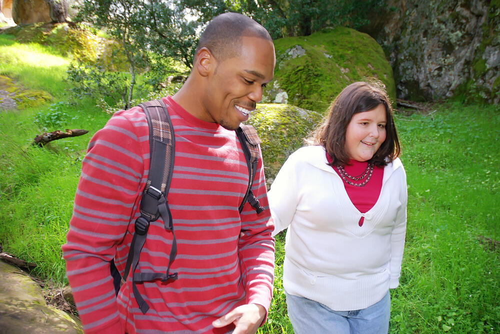 Man assisting a visually impaired woman