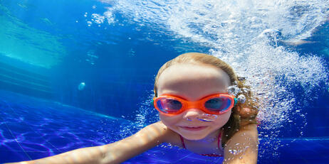 Girl swimming underwater in pool