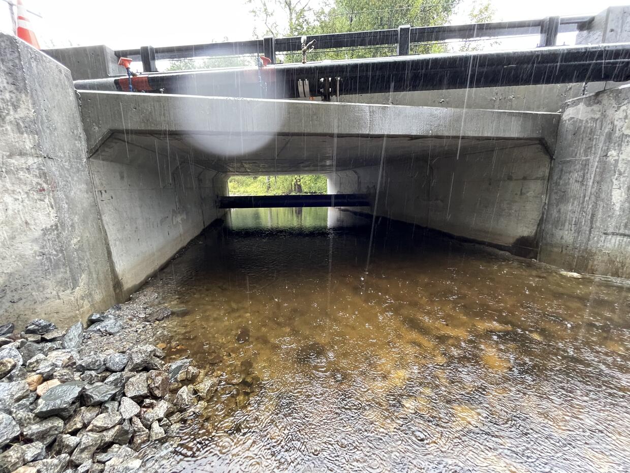 Water flowing under a large culvert.