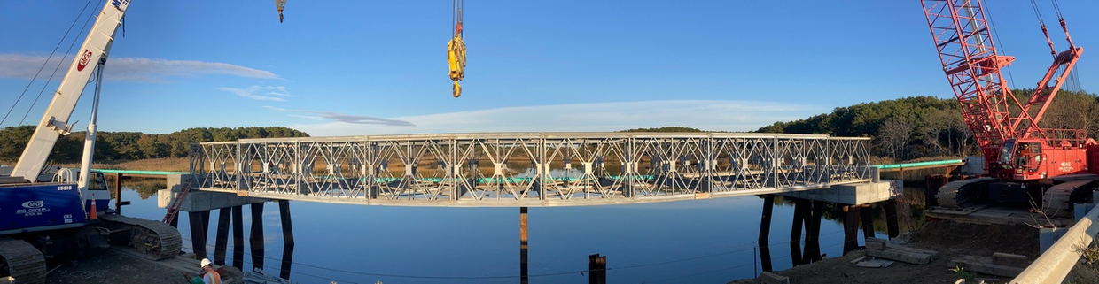 A crane by a temporary bridge over water.