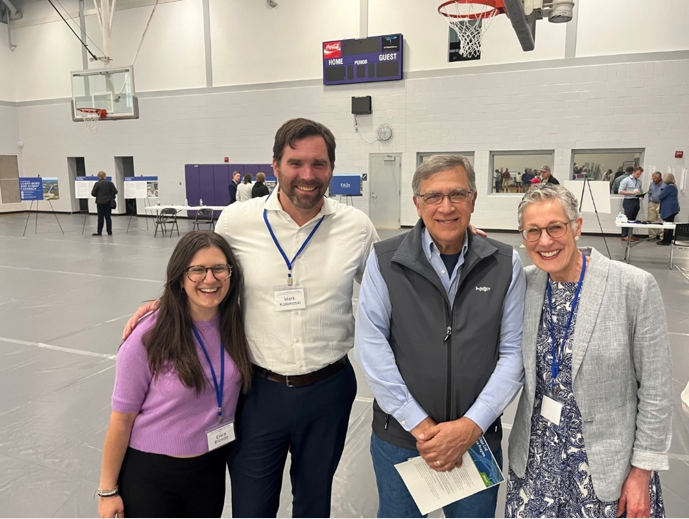 Four people smiling at a public outreach meeting for Cape Cod Bridges