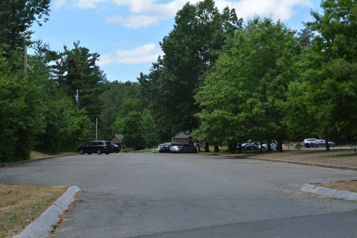 paved parking lot for access to water with a few cars