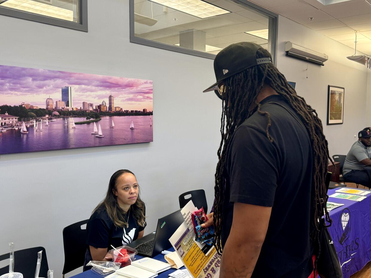 A job fair attendee speaking with a representative from the Mayor's Office of Returning Citizens