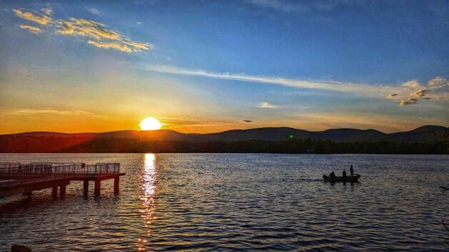 Boaters on Lake Onota in Pittsfield at dusk.