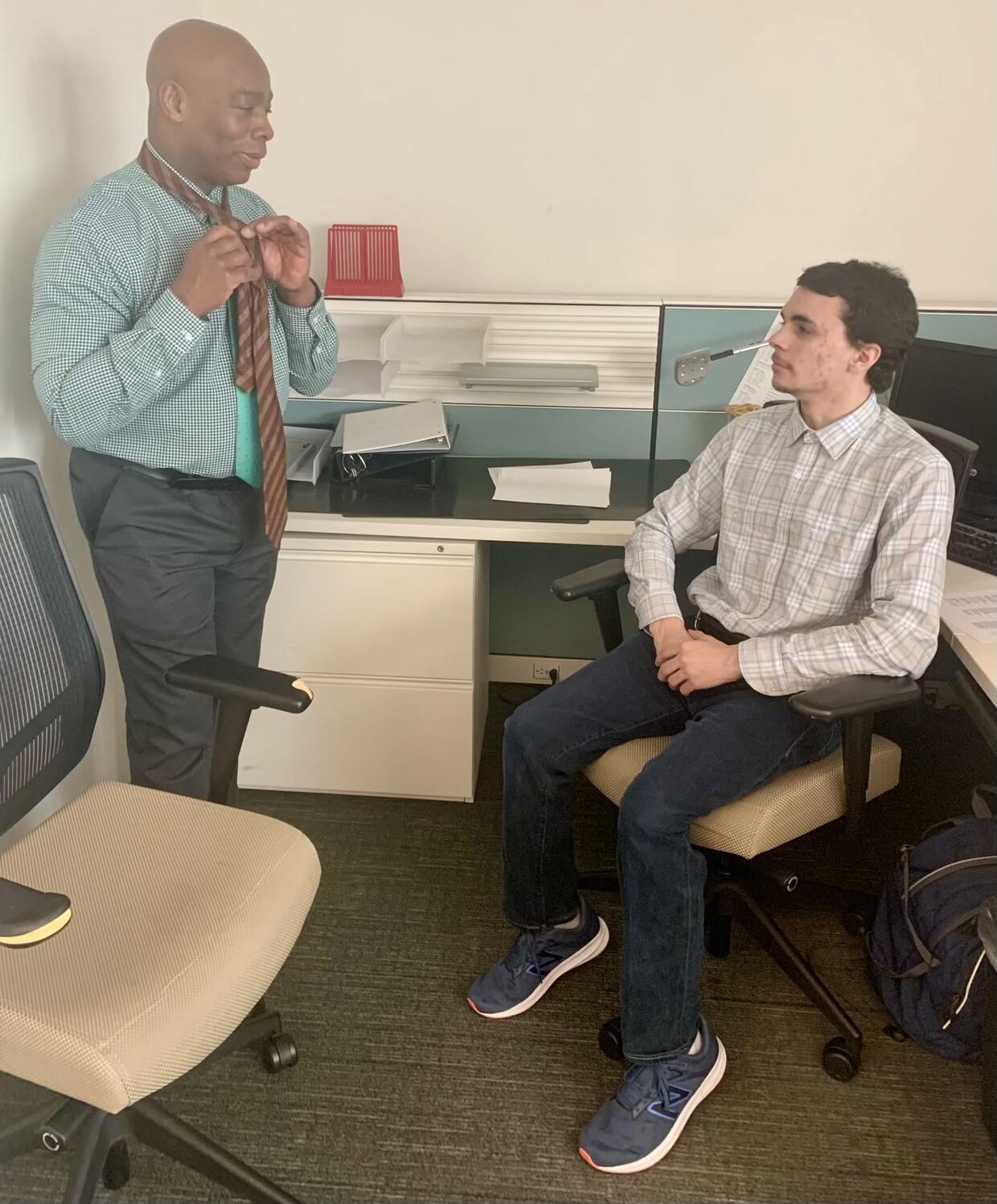 Salem District Probation Officer Dexter McKenzie teaches student Gabriel Ruiz how to tie a tie
