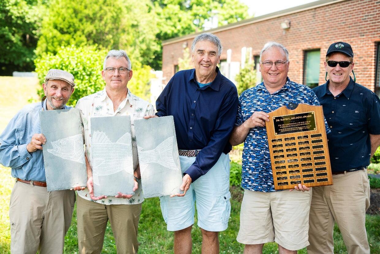 Colleagues celebrating Mike Armstrong, winner of the 2024 Belding Award.