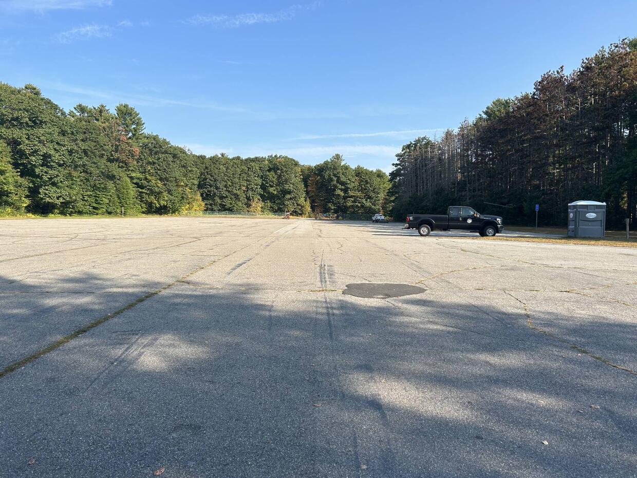 A large, paved parking lot with two cars parked