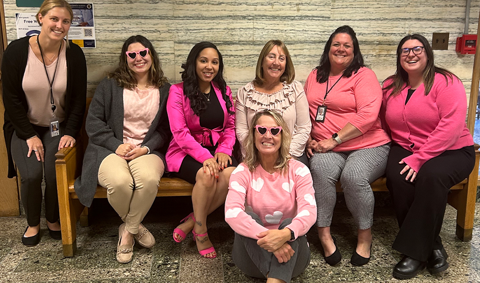 Seven female employees wearing pink.