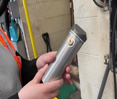 This image shows an example of a farebox probe, a cylindrical object used to remove cash payments from the farebox.