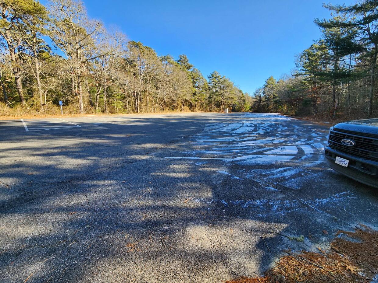 Large paved parking lot with one car parked