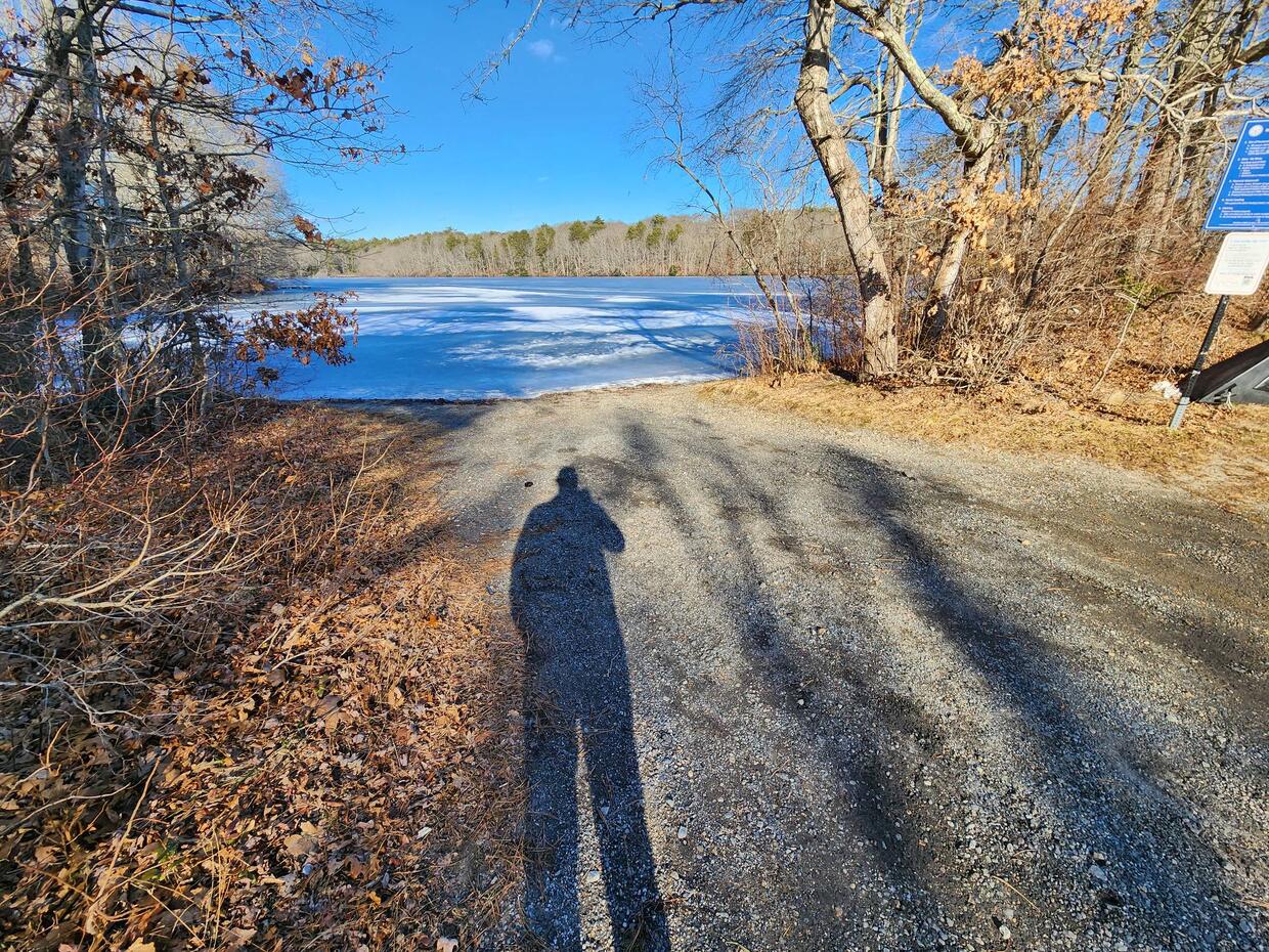 The pond, frozen and covered in snow, from the gravel boat ramp