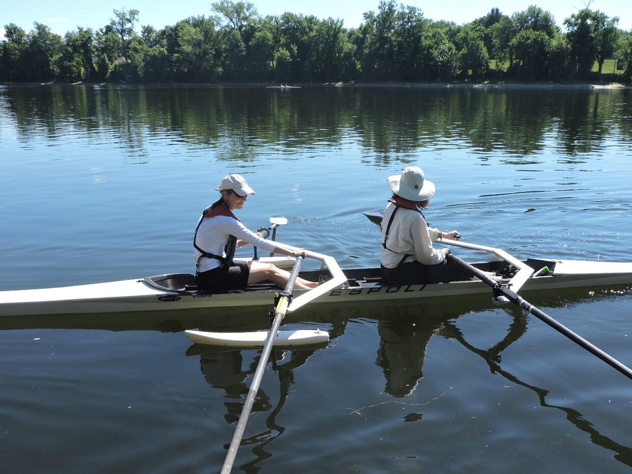 Two people are rowing in a tandem crew boat equipped with pontoons. 