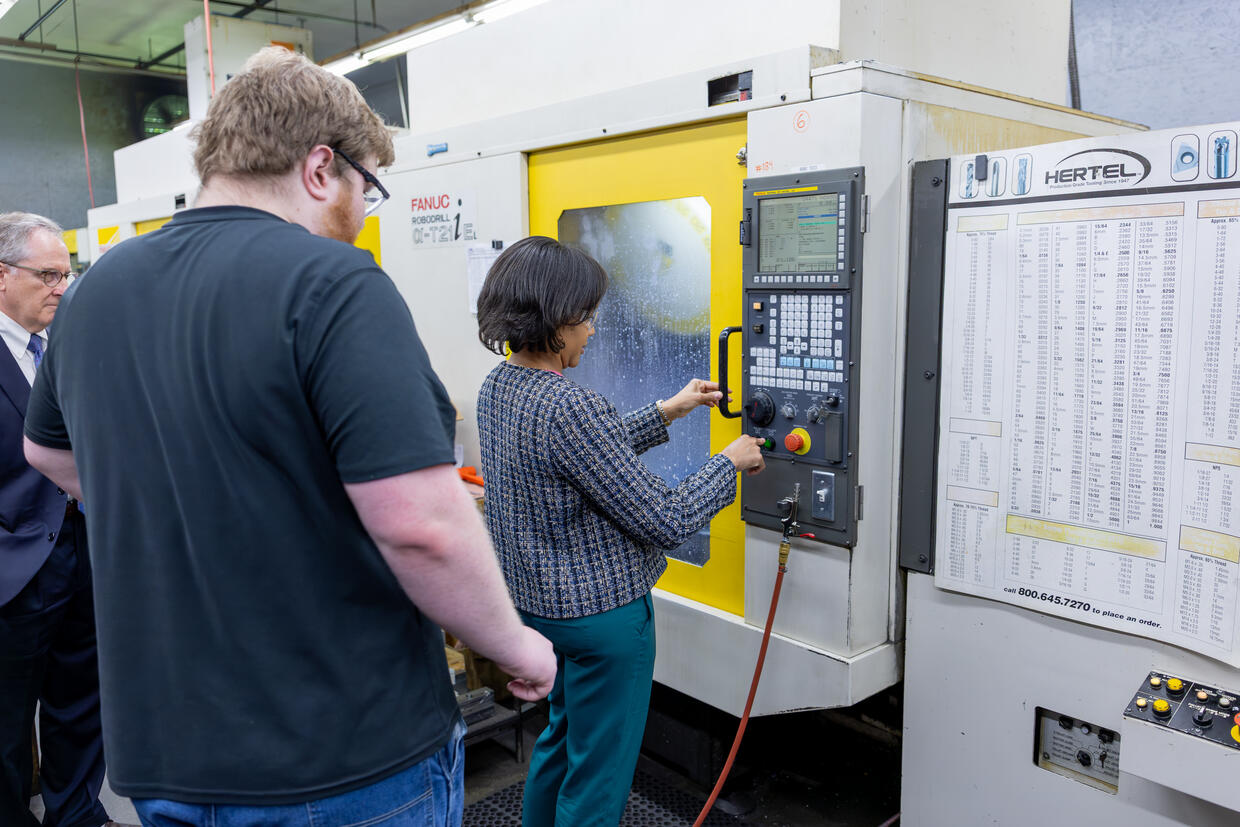 Secretary Jones operates machinery at Evans Machine Co
