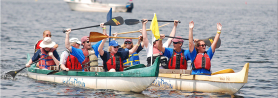 People are cheering while paddling in two Hawaiian outrigger canoes. 