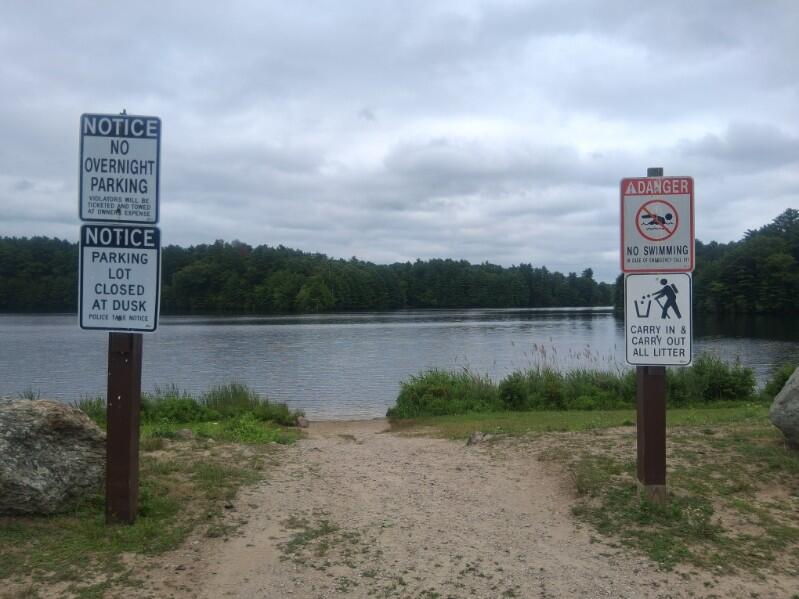 Shore access to the lake with signs prohibiting overnight parking, swimming, and littering