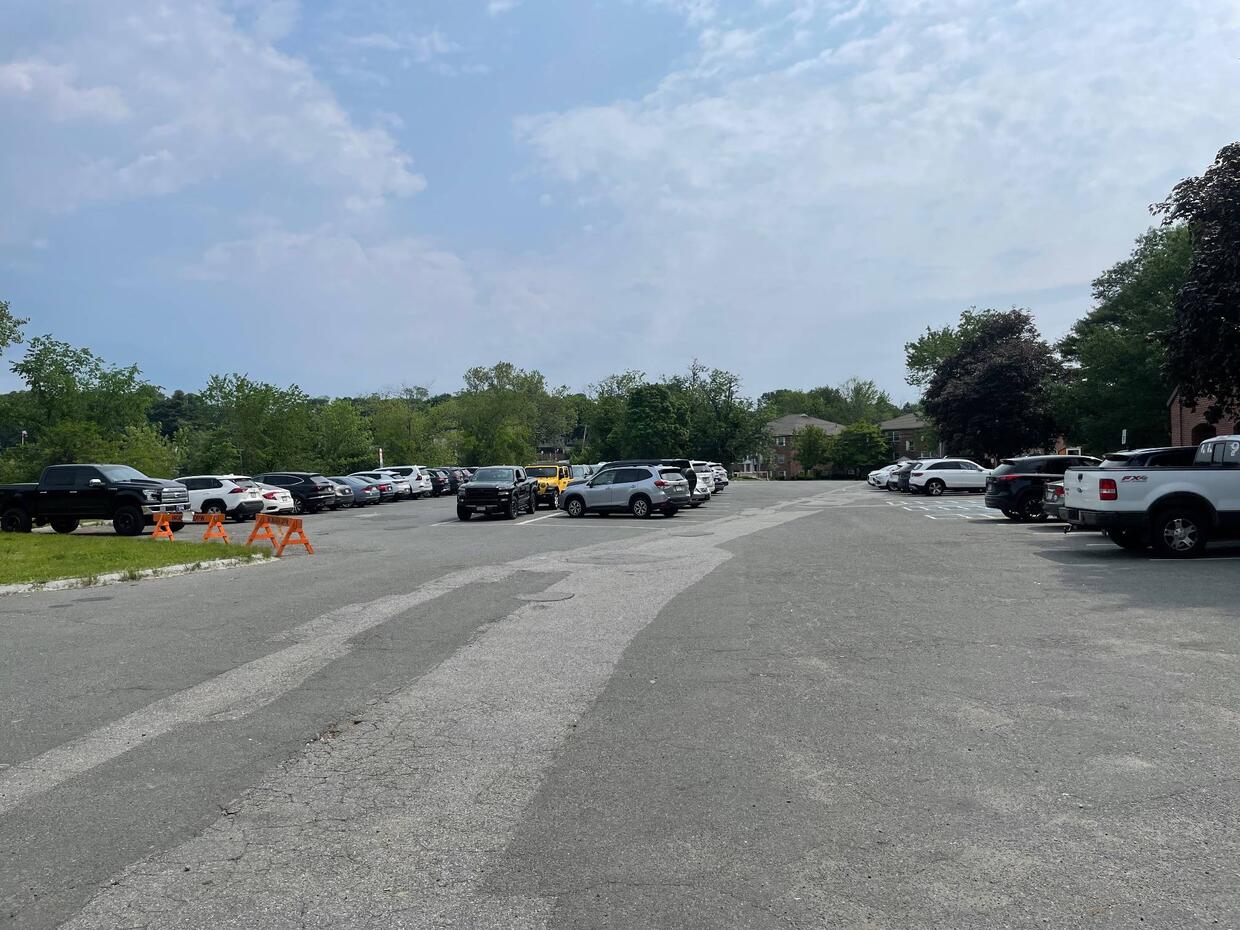 A large paved parking lot with many cars parked