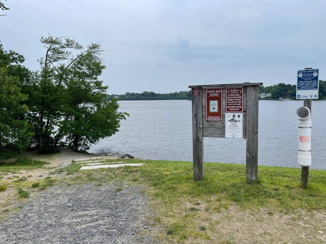 A small, gravel boat launch on a cloudy day