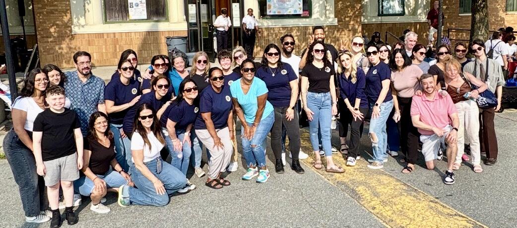 Large group of employees pose outside