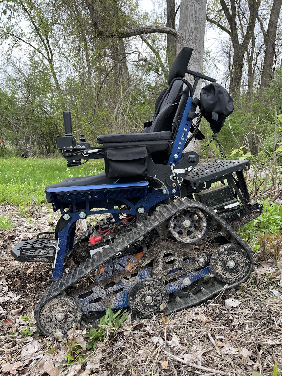 A tracked wheelchair going down a slope.