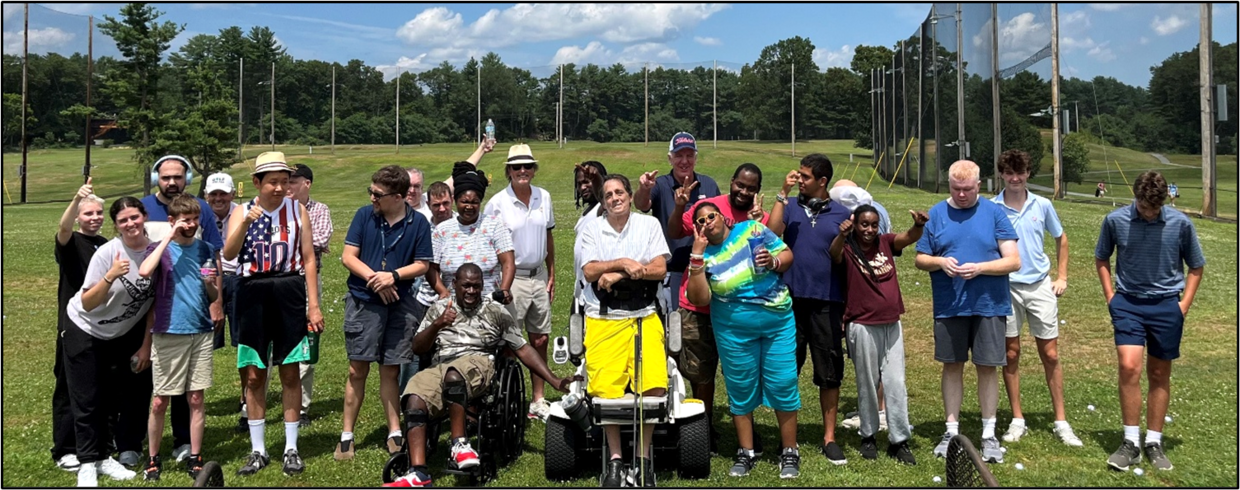 A group of golfers pose for a photo. One  is wearing headphones, one is using a wheelchair and one is standing with a ParaGolfer. 