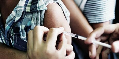 Person getting a vaccine in their arm.