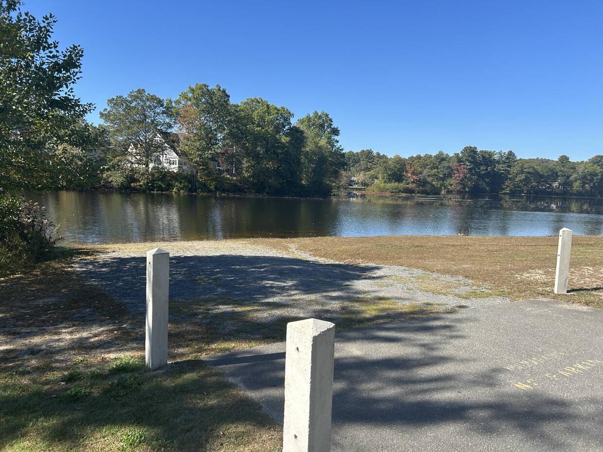 A short, unpaved boat ramp overlooking calm water