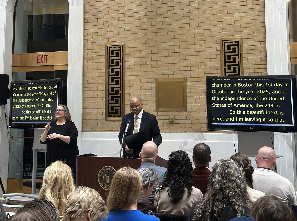 Health and Human Services Secretary Kiame Mahaniah standing at the podium addressing the audience