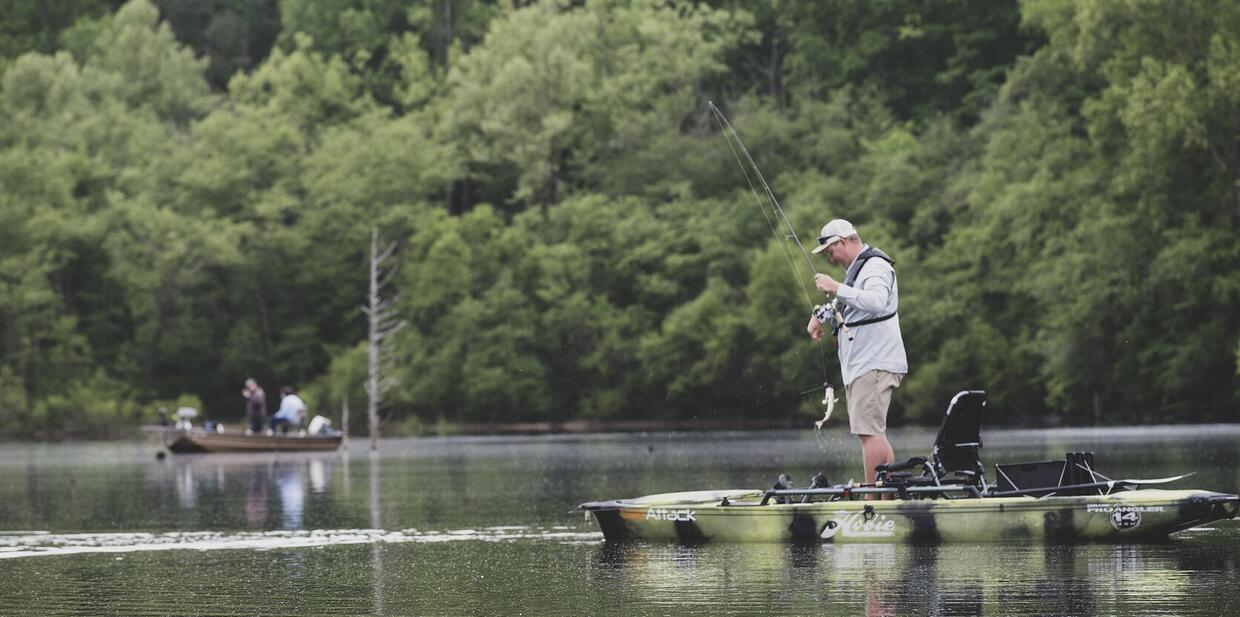 photograph of a man in a kayak fishing