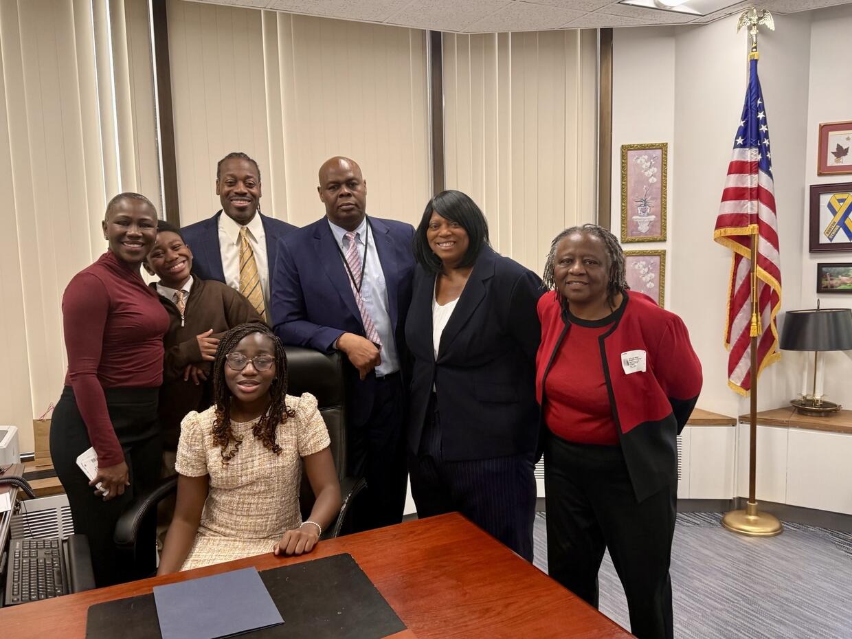 A group of people in an office with the American flag in the background