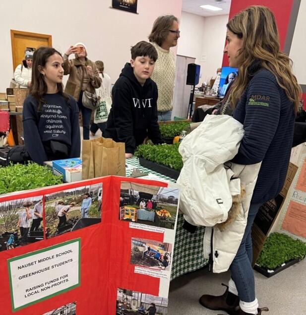Commissioner Randle speaking with middle school students at the Orleans Winter Farmers Market