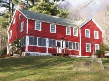 Front view of Swann Lodge, a red two-story lodge building with a porch.