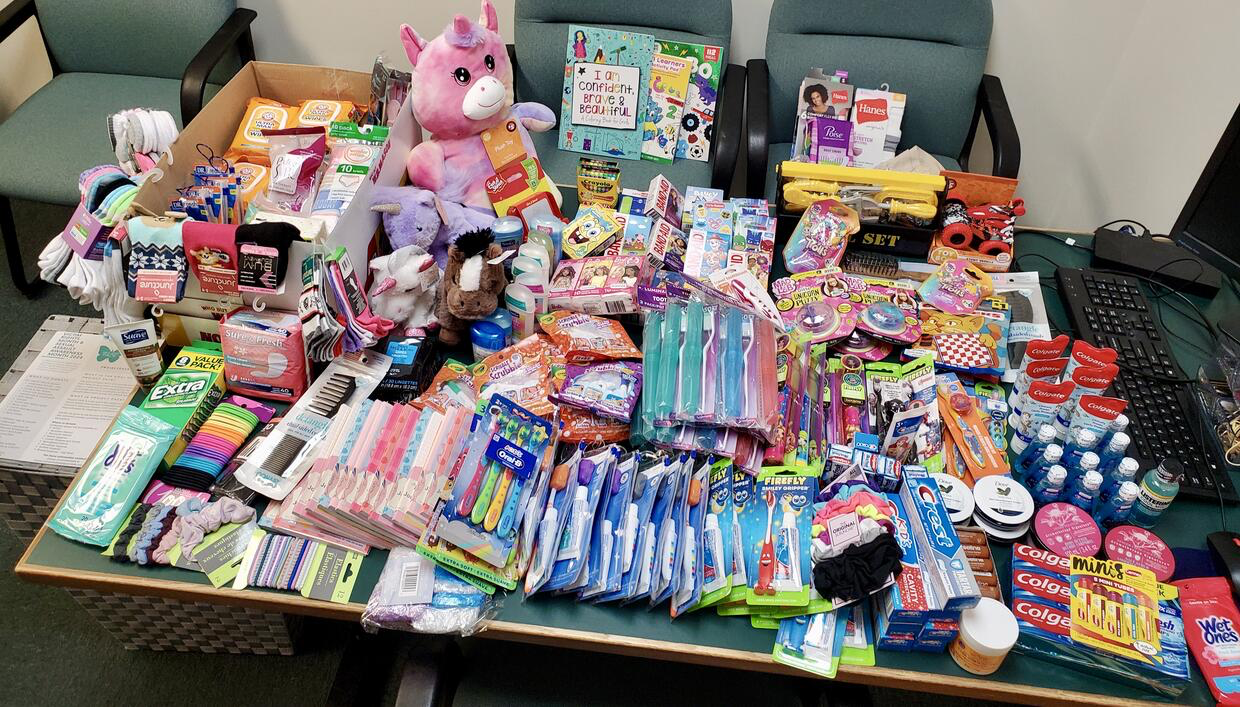 A table displaying personal hygiene items, socks, and stuffed animals.