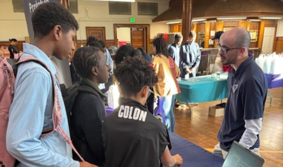A man speaks with a group of school-age children