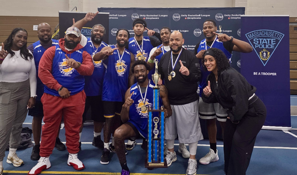 A large group pose together with the Boston Strong Invitational winners trophy