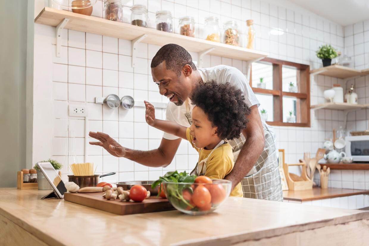 Father and child preparing a meal in the kitchen together