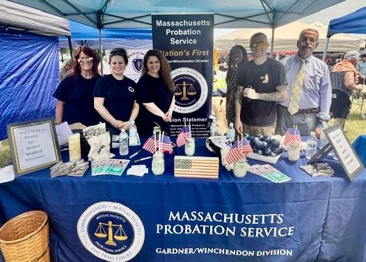 Six people from the MPS staffing a booth at an outdoor event.