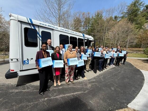 A group stands in front of a bus