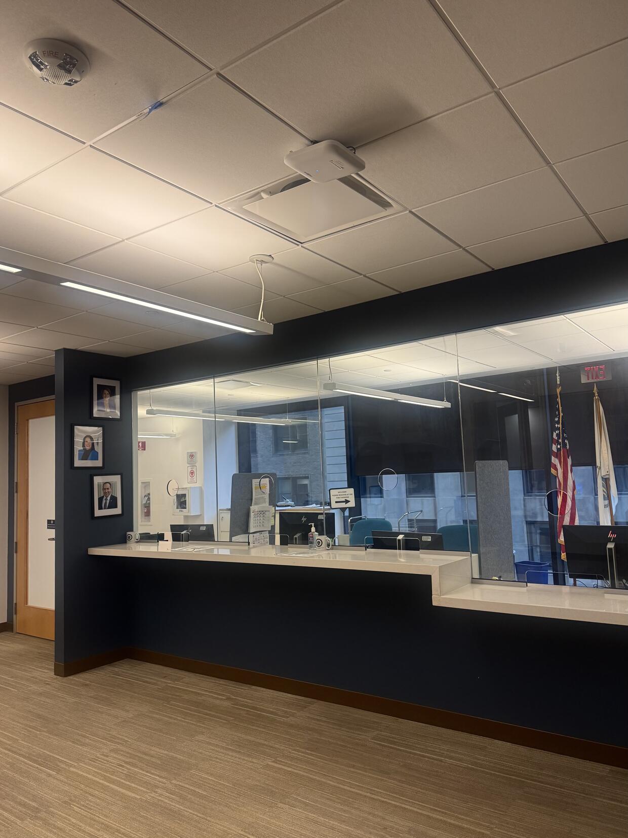 An office reception area with a long counter and glass partition.