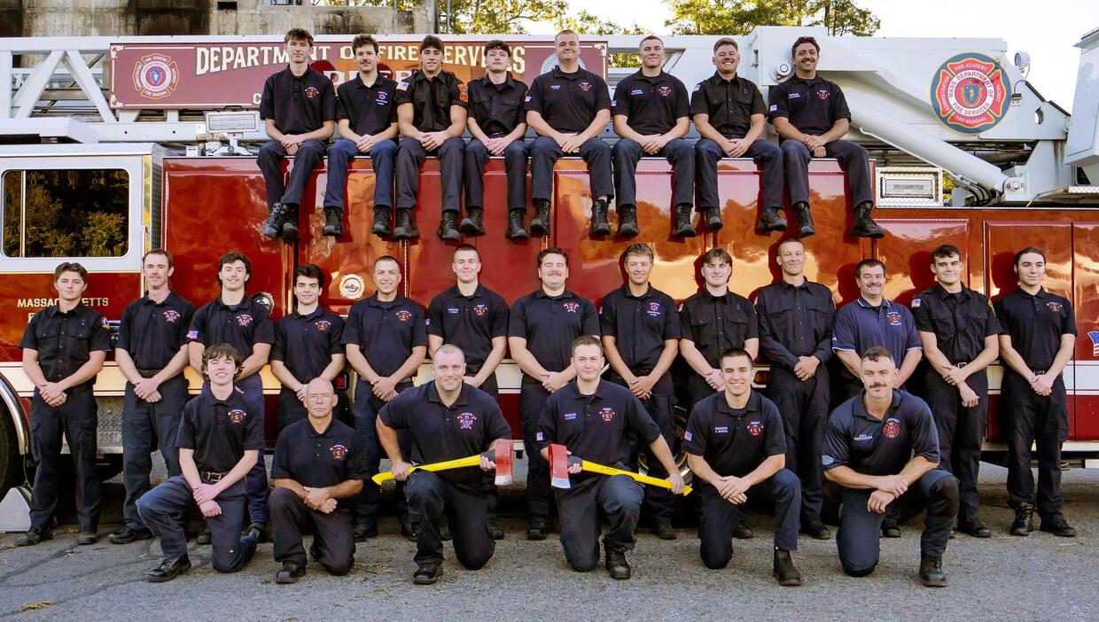 26 new firefighters on and around a ladder truck
