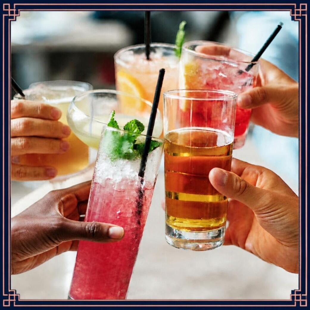 People raising glasses of colorful cocktails in a manner as if to say CHEERS