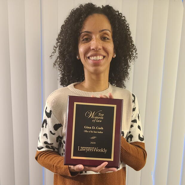 Gina Cash holding a plaque from Massachusetts Lawyer's Weekly.