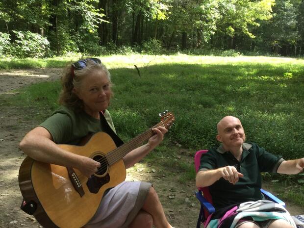 Cheryl plays guitar while Glenn moves outdoors