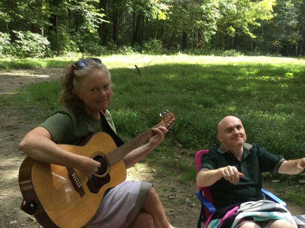 Cheryl plays guitar while Glenn moves outdoors 