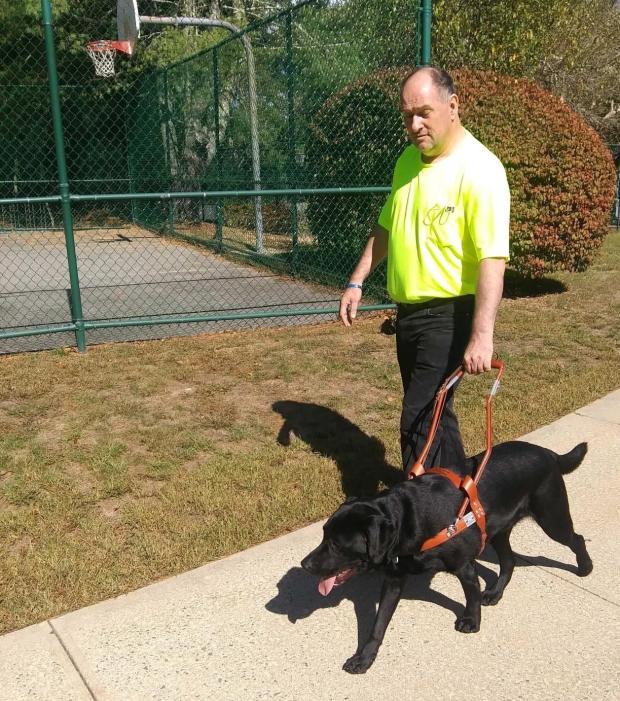 MCB Consumer Peter Akuses and Guide Dog Ryker go for a walk outside together