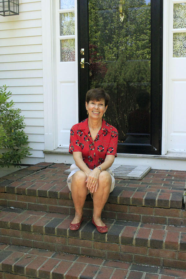 Bela sits on the steps in front her home