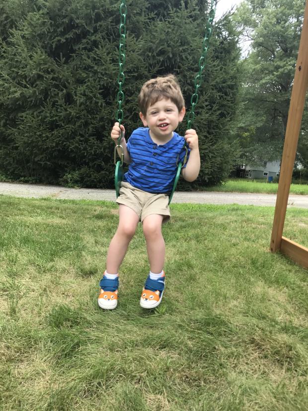 Image of a young boy with CVI on a swing